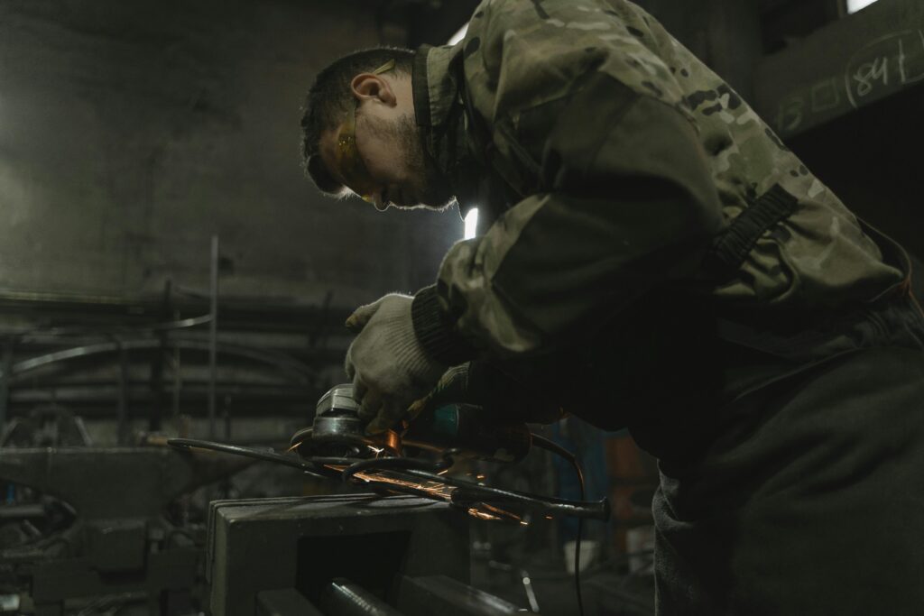 pexels-photo-5846153-5846153 A craftsman skillfully operating a grinder, sparks flying, in an industrial workshop setting.