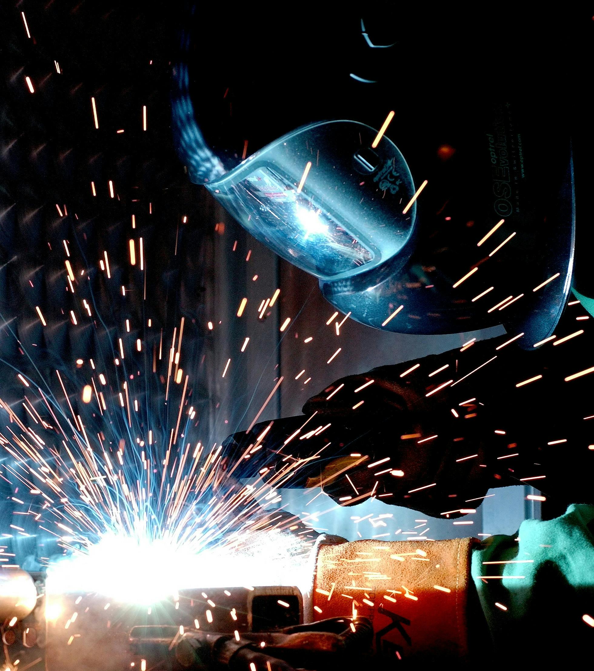 weld-hot-soldering-radio-welder-73833-73833 A focused welder works with metal in an industrial setting, creating vibrant sparks.